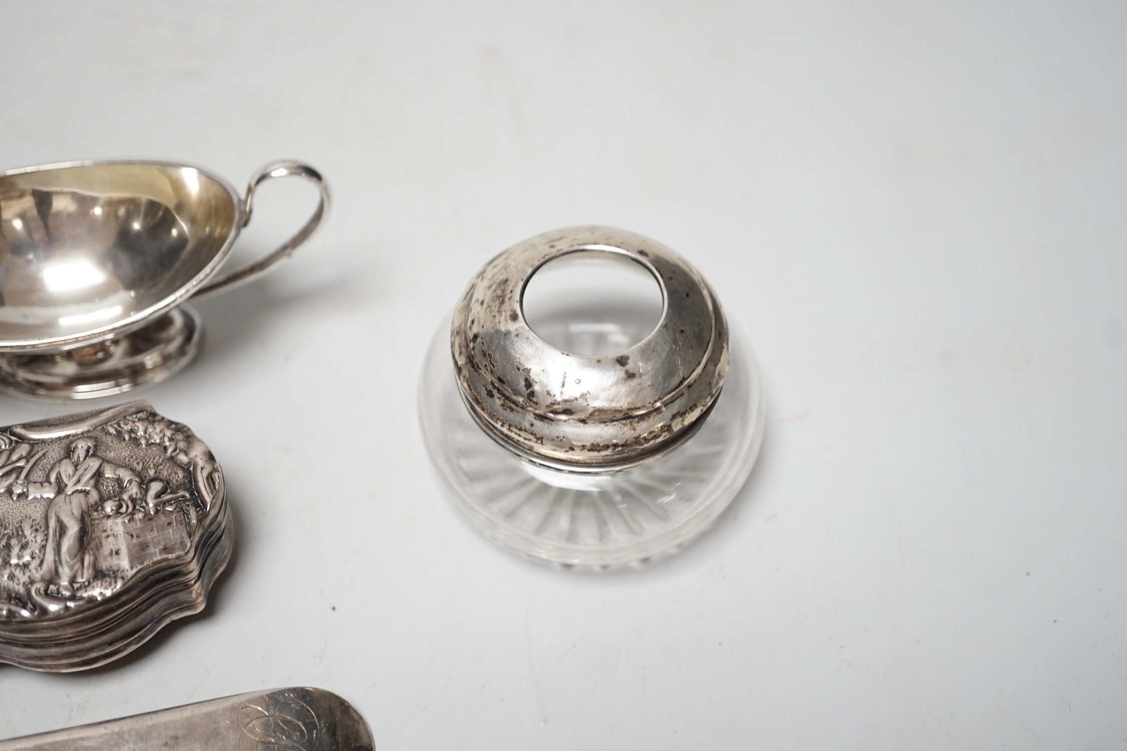 A set of four Edwardian silver two handled boat shaped salts, London, 1901, width 10.5cm, two 18th century silver base mark table spoons, a continental white metal snuff box and a silver mounted glass tidy.